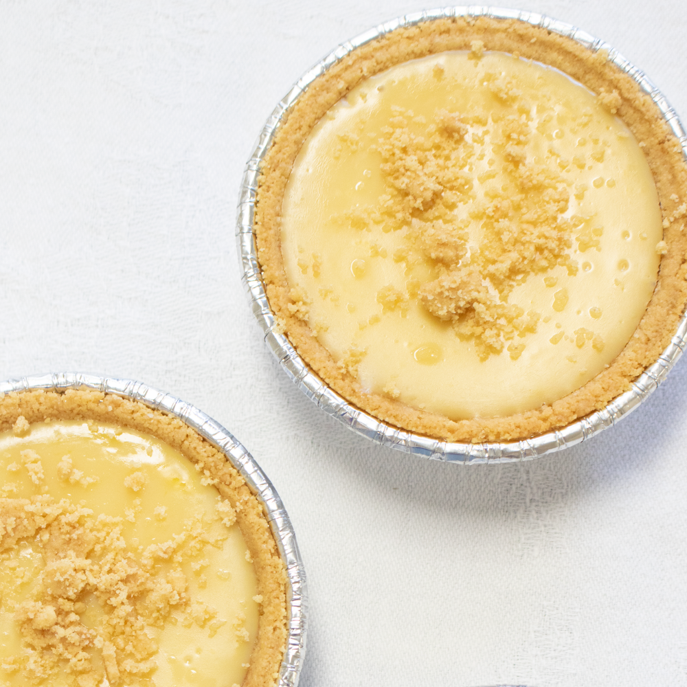 Two small key lime pies on a white background